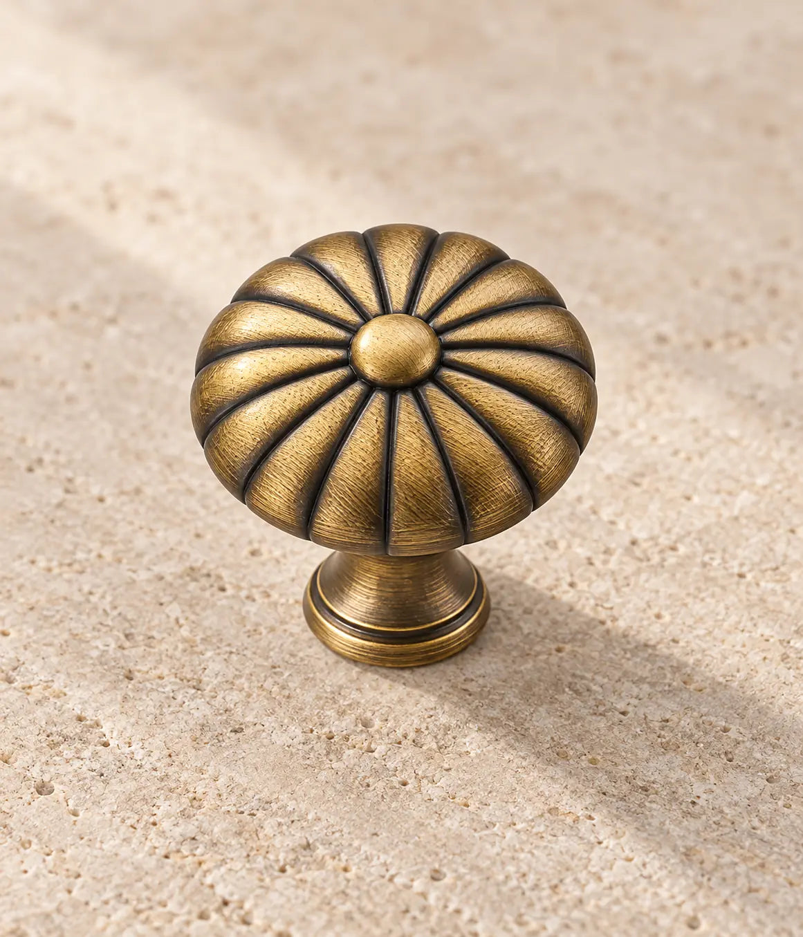 Close-up of the raised center and radial grooves on the antique brass knob