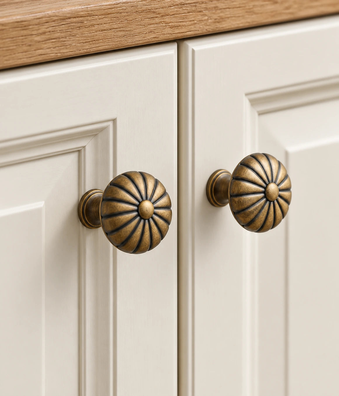 Antique brass fluted button knobs fitted to ivory cabinet doors