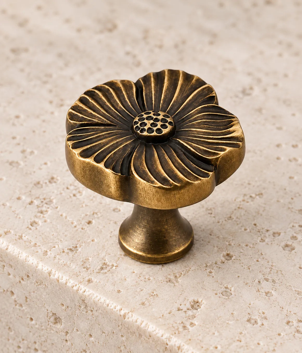 Close-up of curved flower grooves and dotted center on antique brass knob