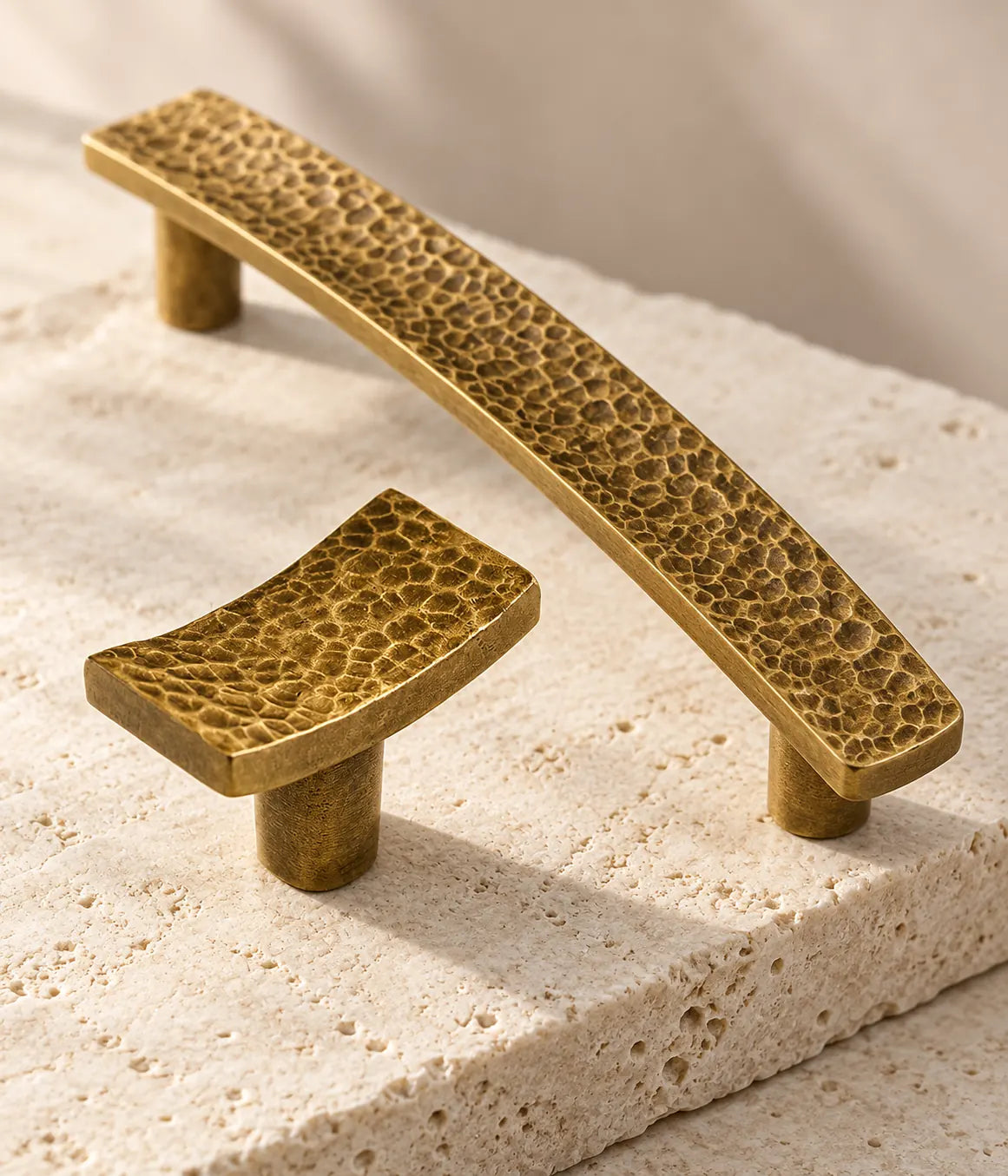 Close-up of irregular hammered texture on antique brass rectangular knob and slim pull
