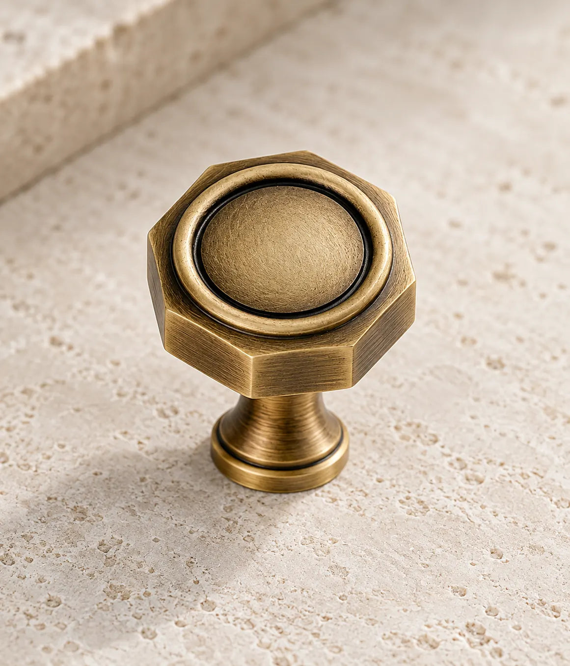 Close-up of the octagonal brass knob face, circular rim and waisted stem