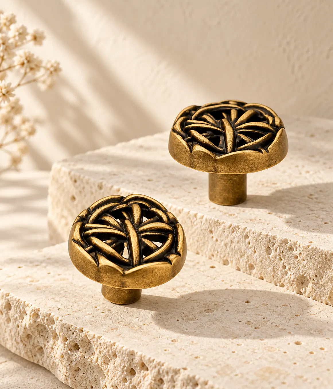 Antique brass openwork weave cabinet knobs arranged on pale limestone ledges