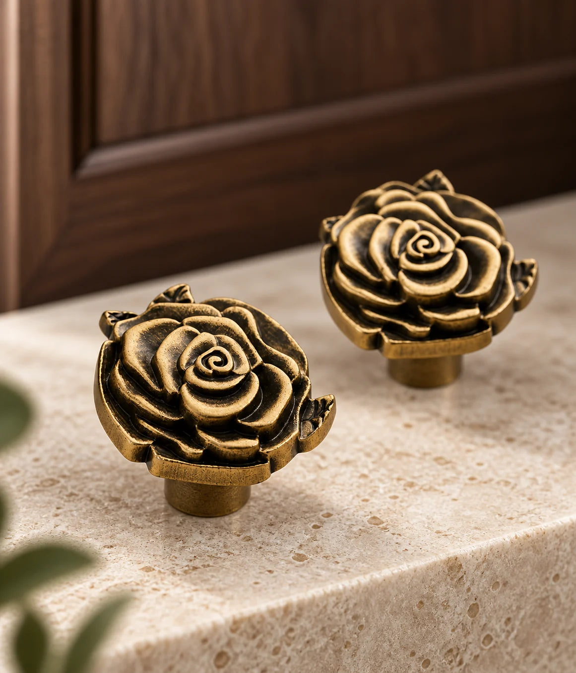 Sculpted antique brass rose knobs beside walnut cabinetry
