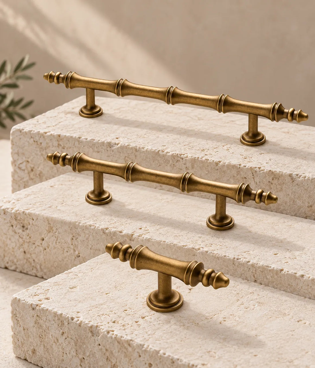 Antique brass segmented-finial cabinet pulls and matching T-knob on ivory limestone