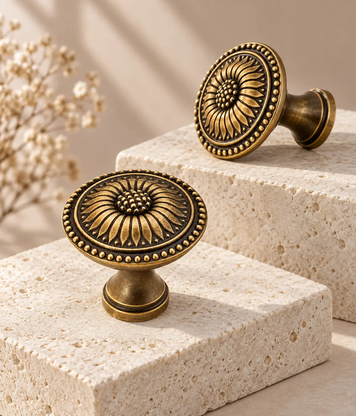 Antique brass sunflower cabinet knobs arranged on ivory limestone