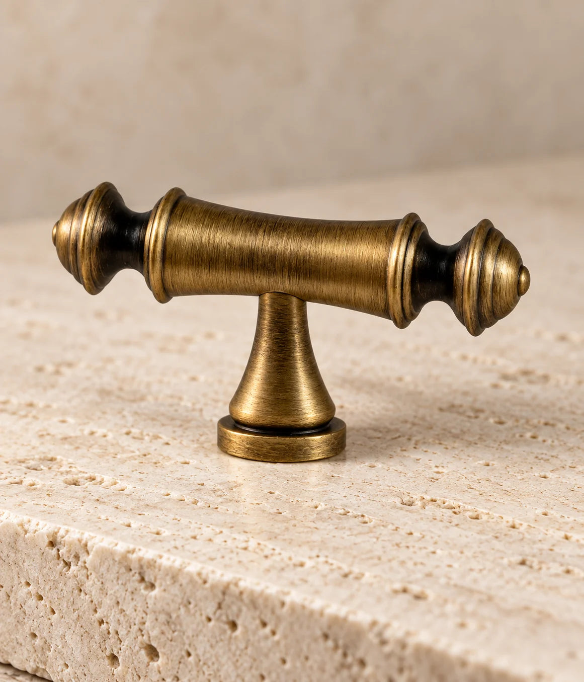Close-up of the stepped finials and smooth waisted grip of the antique brass T-knob