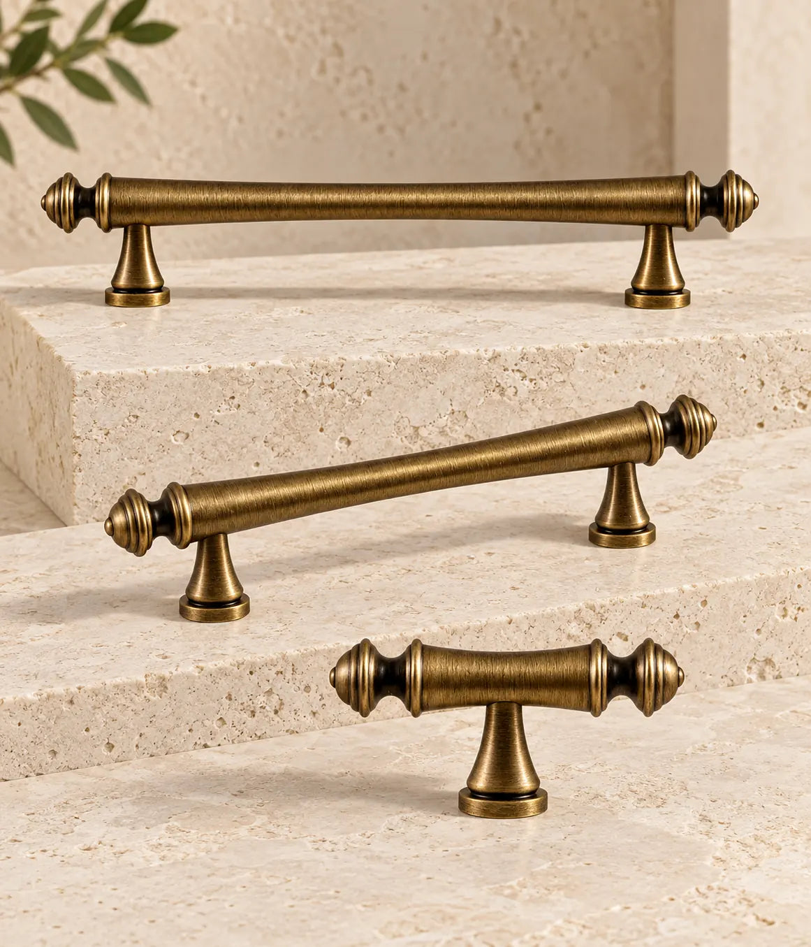 Antique brass turned-finial cabinet pulls and matching T-knob arranged on ivory limestone