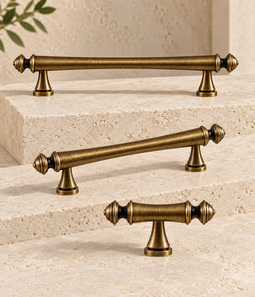 Antique brass turned-finial cabinet pulls and matching T-knob arranged on ivory limestone