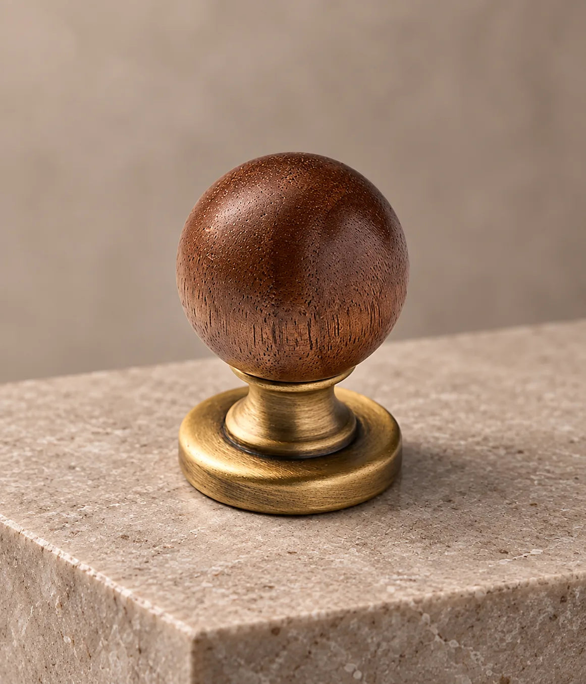 Close-up of walnut ball cabinet knob with turned antique brass stem and round base