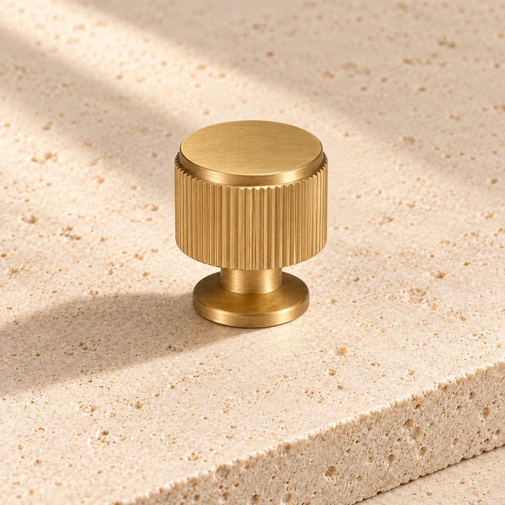 gold brass linear round knob on pale limestone.