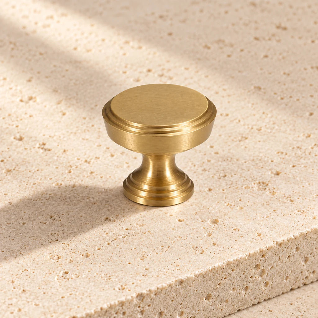 gold brass stepped round knob on pale limestone.