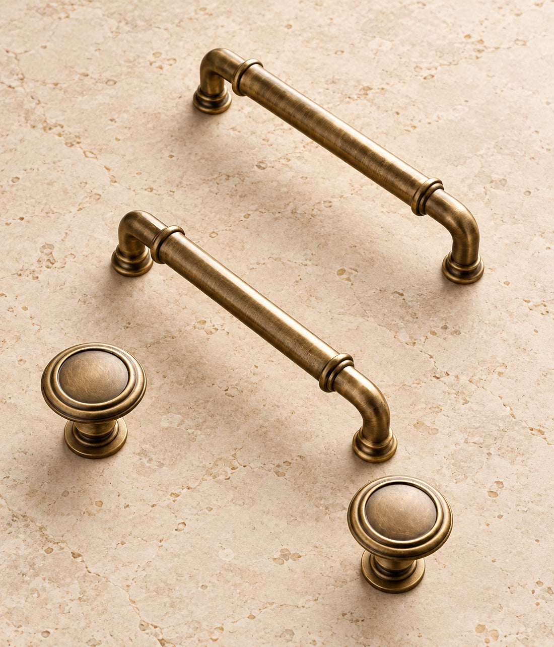 Antique Brass Collared Cabinet Pulls & Knob on warm limestone, showing the antique brushed brass finish