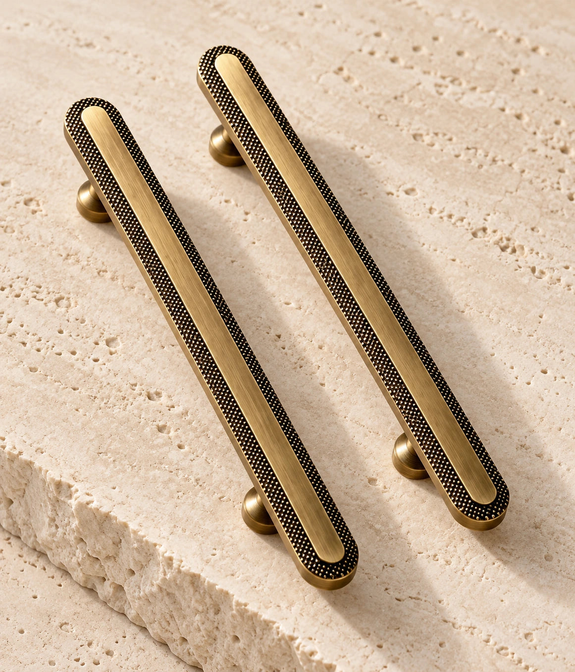 Antique Brass Knurled Rim Cabinet Pulls & Knob on warm limestone, showing the antique brushed brass finish