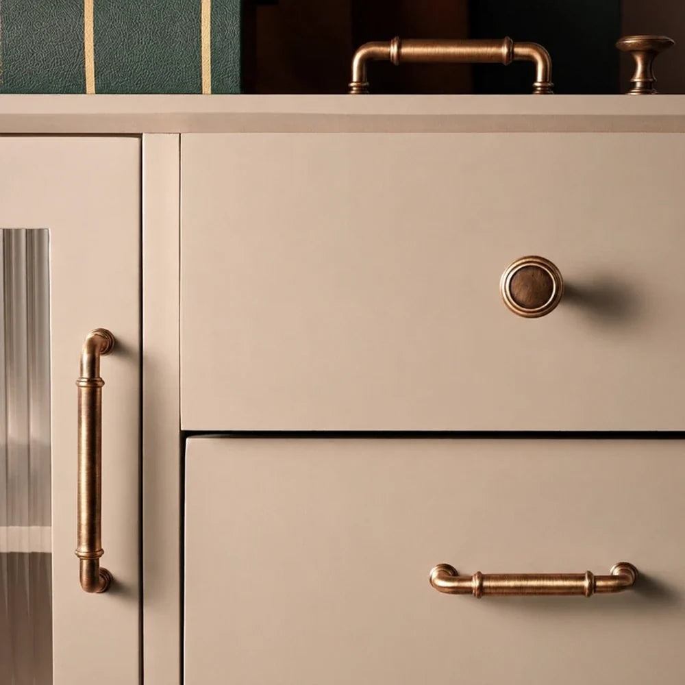 Antique brass collared pulls and knobs installed on cream cabinetry