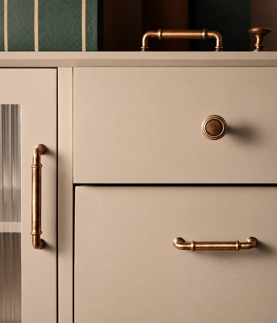 Antique brass collared cabinet pulls and knobs arranged on rust fabric
