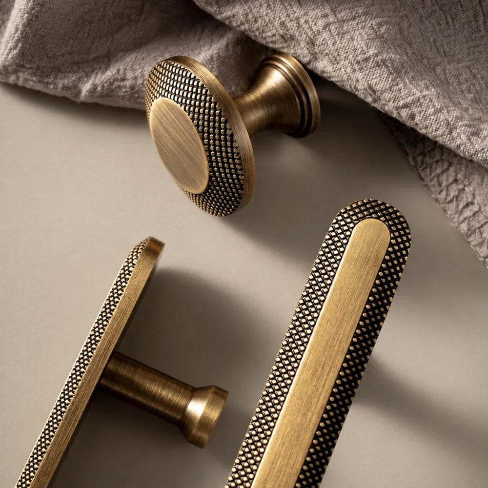 Antique brass knurled hardware arranged on beige fabric