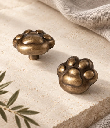 Antique brass paw cabinet knob shown in two views on limestone