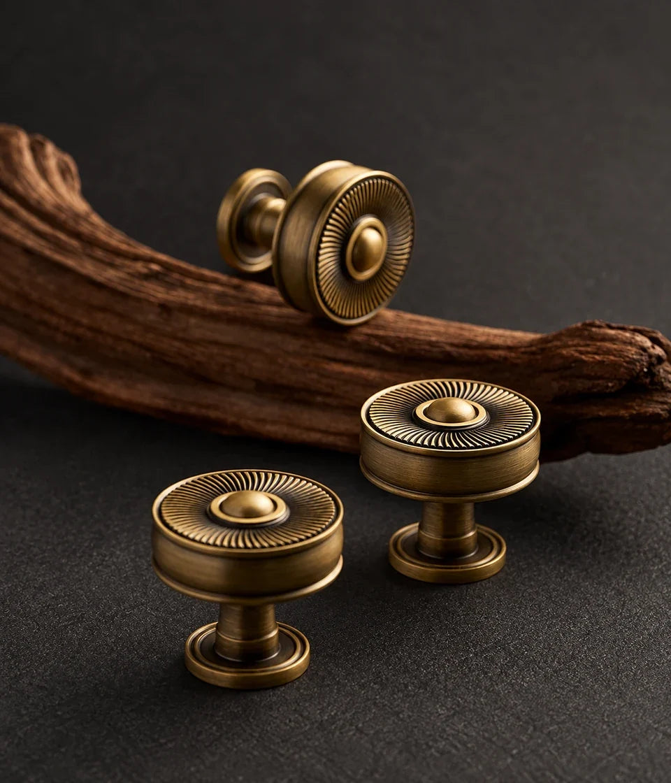 Antique brass sunburst knobs showing domed centers and fine radial detailing
