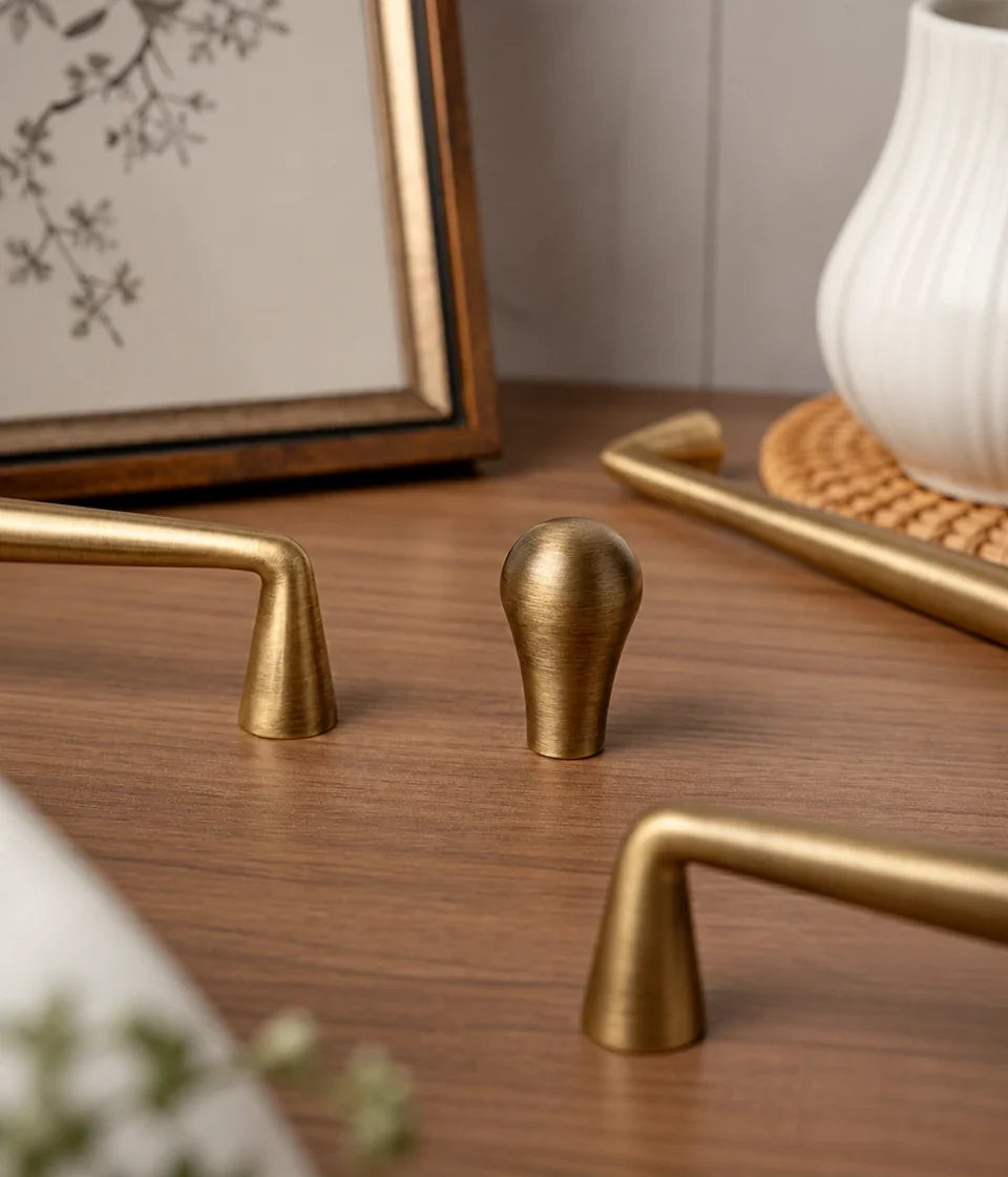 Antique brushed brass tapered cabinet pulls and teardrop knob on wood