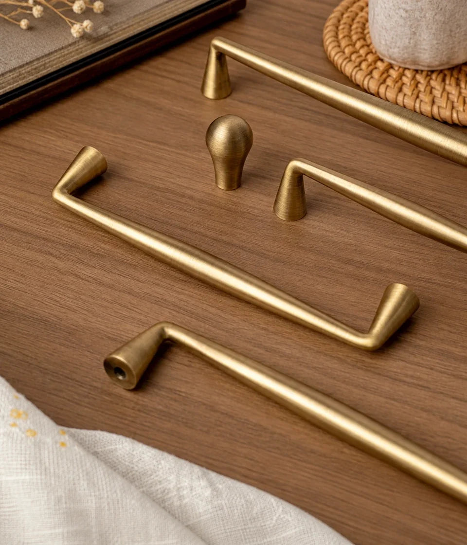 Antique brushed brass tapered cabinet pulls and teardrop knob on wood