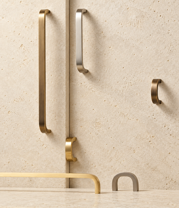 Solid Brass Bent Handle displayed on pale limestone.