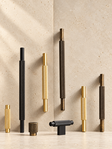 Solid Brass Cross Knurled Handle displayed on pale limestone.