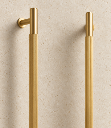 Solid Gold Brass Linear Handle displayed on pale limestone.