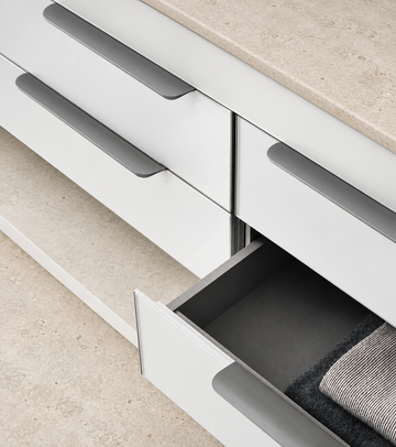 Hidden Cabinet Edge Pull Handle displayed on pale limestone.