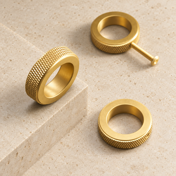 Solid Brass Knurled Ring Cabinet Knob displayed on pale limestone.