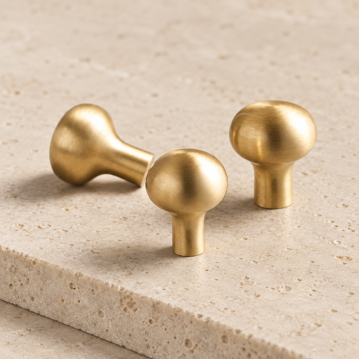 Solid Brass Smooth Round Cabinet Knob on pale limestone.