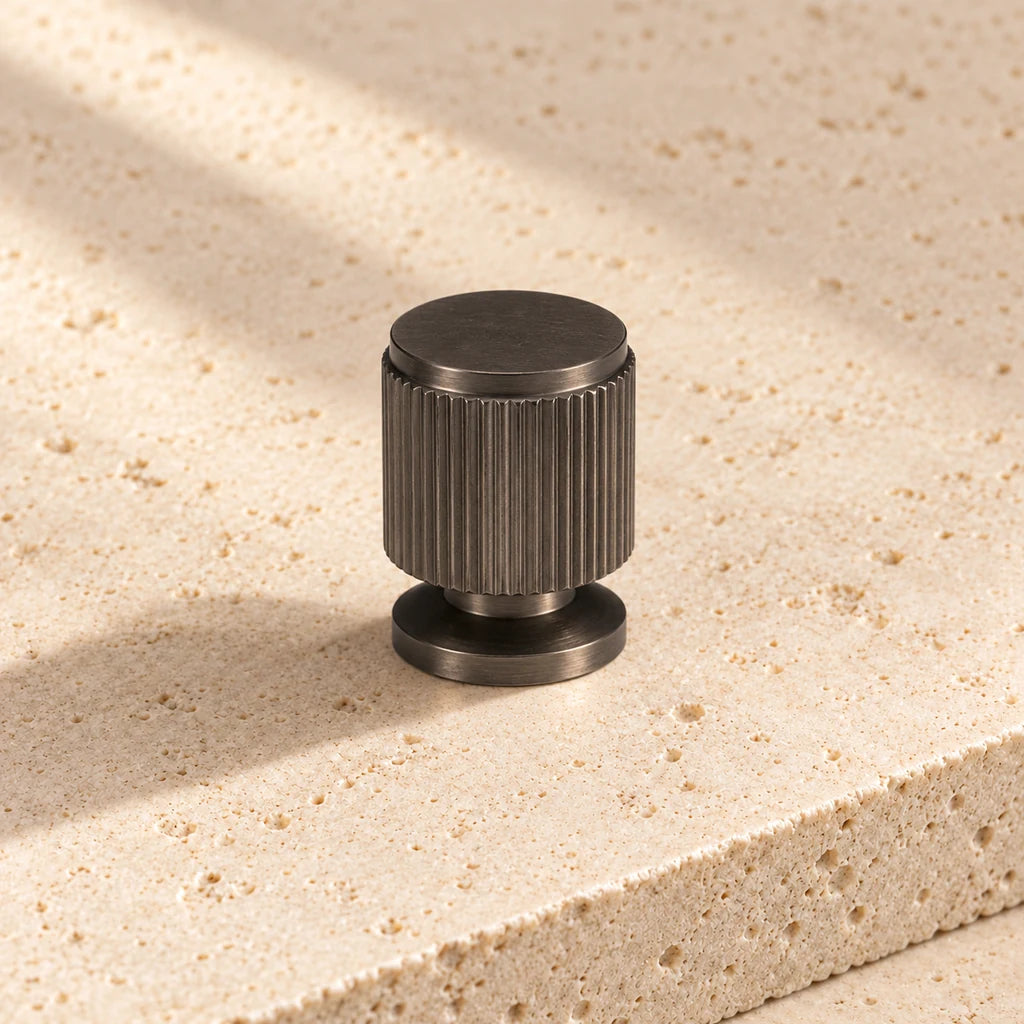 gunmetal linear cabinet knob on pale limestone.
