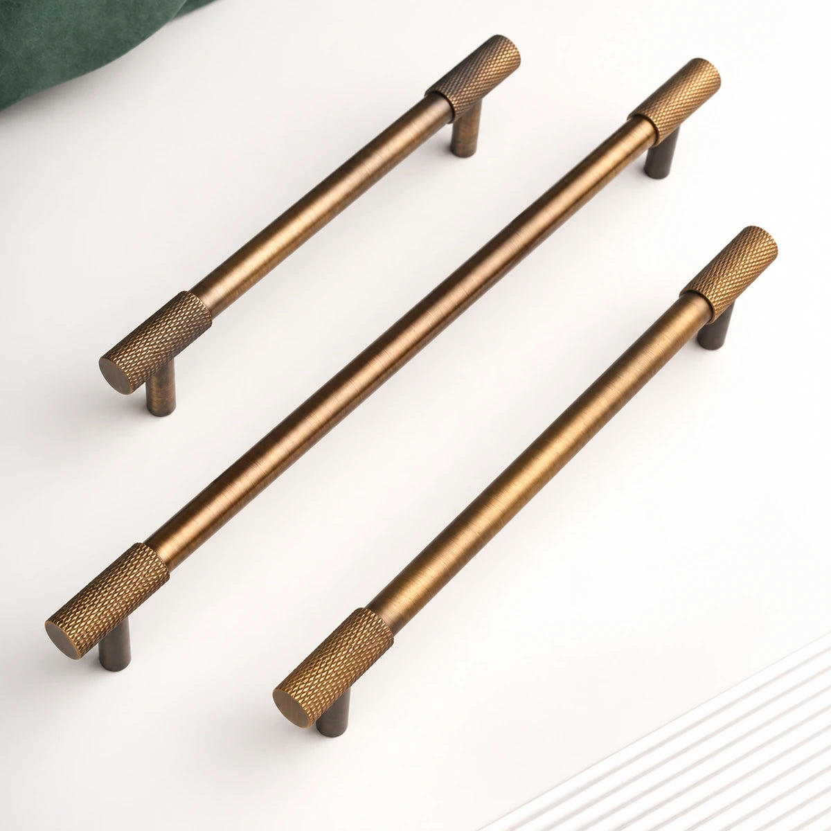 Three antique brass knurled end cabinet pulls with straight round posts