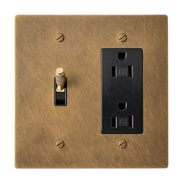 Two-gang unlacquered antique brass (hand-brushed) plate with one brass knurled toggle switch with a black plastic insert and one black regular 15A duplex outlet.