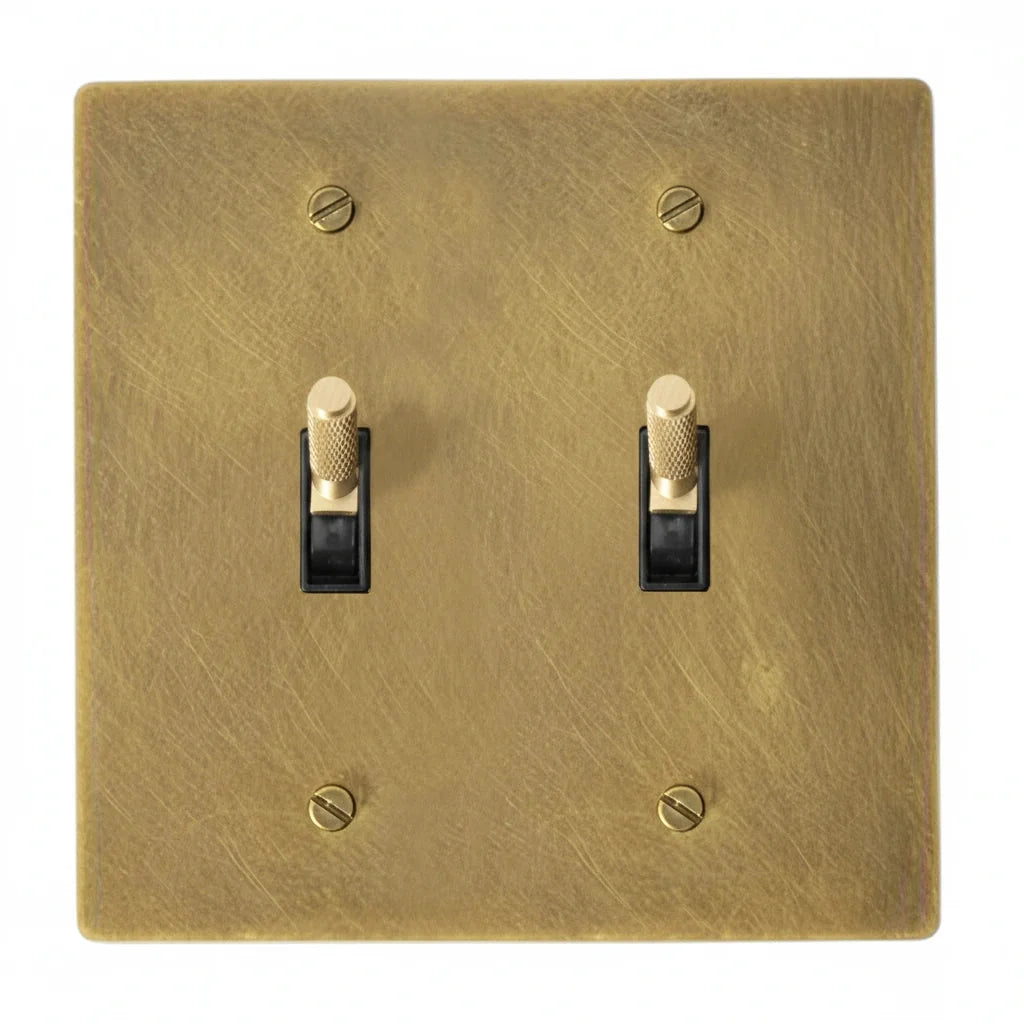 2-gang unlacquered antique brass (hand-brushed) plate. Two brass knurled toggle switches with black plastic inserts.