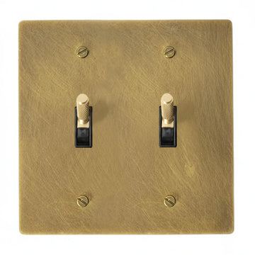 2-gang unlacquered antique brass (hand-brushed) plate. Two brass knurled toggle switches with black plastic inserts.