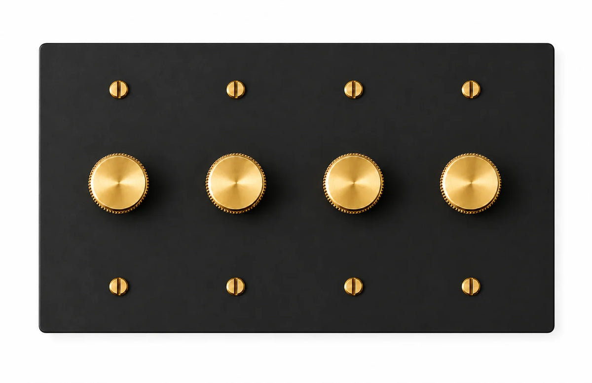 Matte black four-gang plate with four brass rotary dimmer knobs and eight brass screws