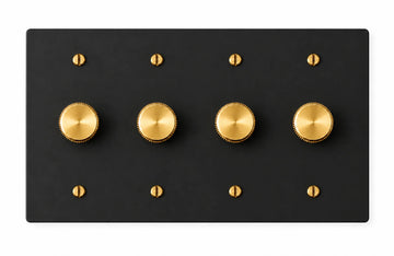 Matte black four-gang plate with four brass rotary dimmer knobs and eight brass screws