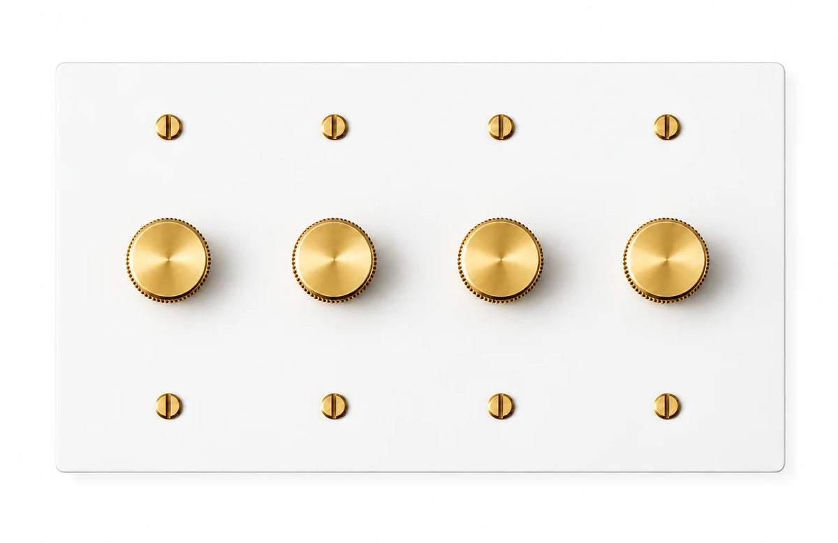 White four-gang plate with four brass rotary dimmer knobs and eight brass screws