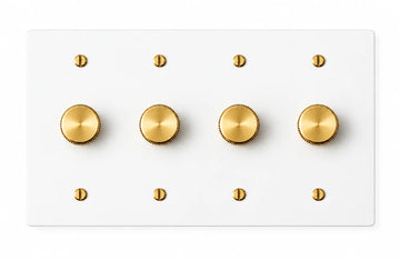 White four-gang plate with four brass rotary dimmer knobs and eight brass screws