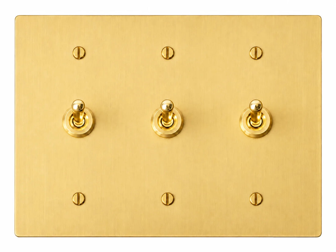 Satin Brass three-gang plate with three smooth retro brass toggle switches and six brass screws