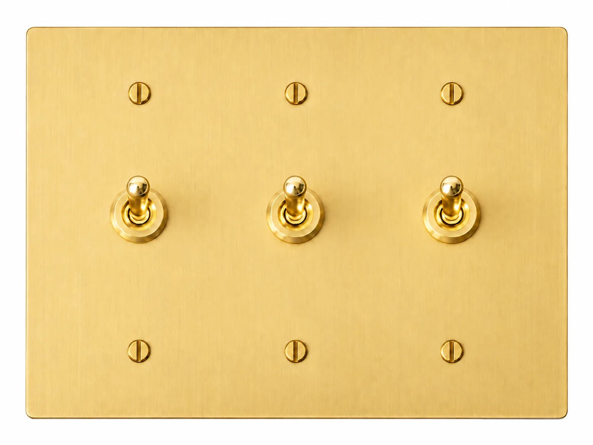 Satin Brass three-gang plate with three smooth retro brass toggle switches and six brass screws