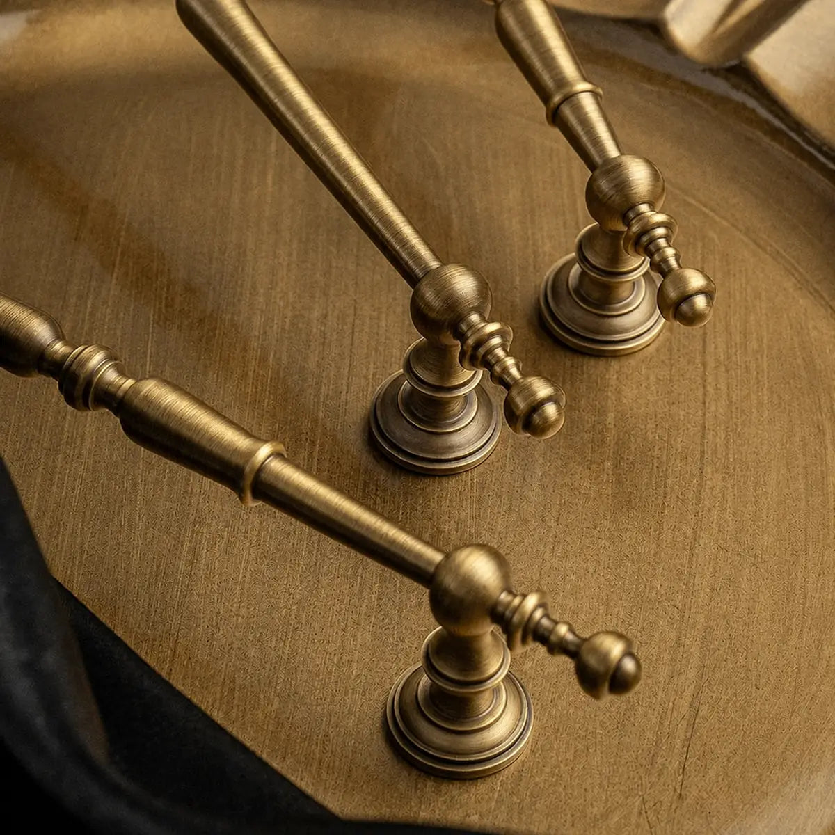 Stepped round bases and turned grip details on ornate brass pulls