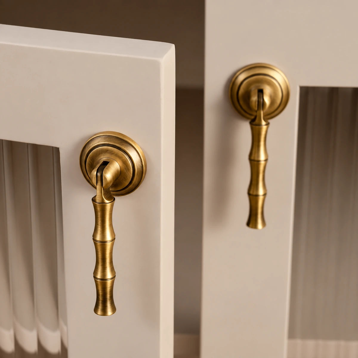 Antique brass bamboo pendant pulls installed on cream cabinet doors