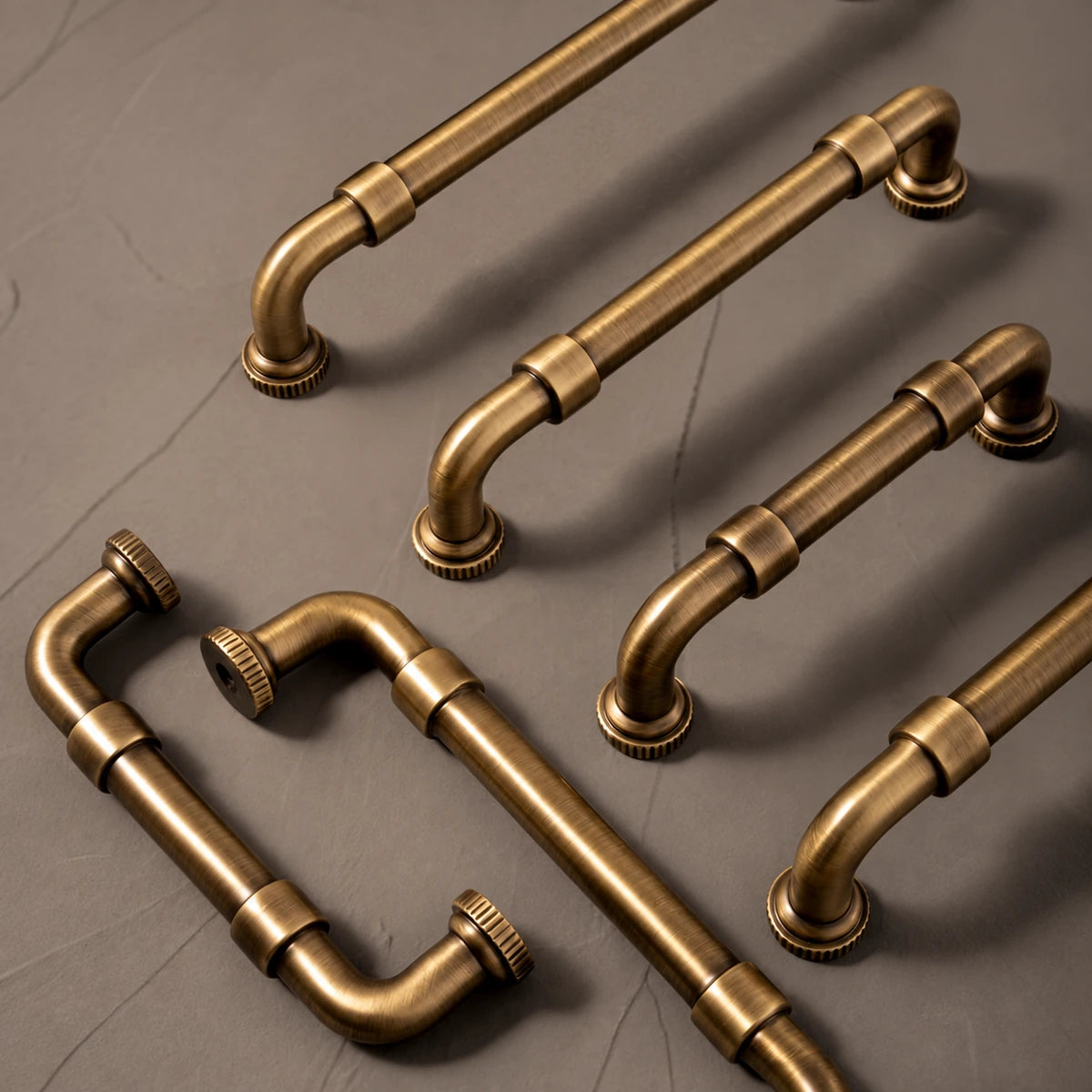 Antique brass pipe cabinet pulls arranged on stone