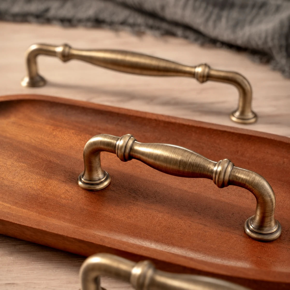 Ringed bow cabinet pulls with flared bases and antique brass finish