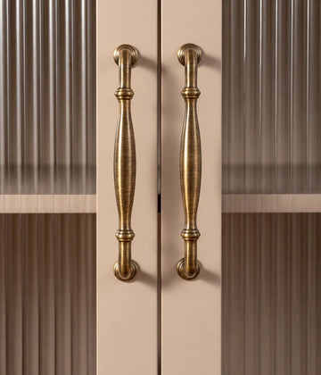Antique brass ringed bow pulls on fluted glass cabinet doors