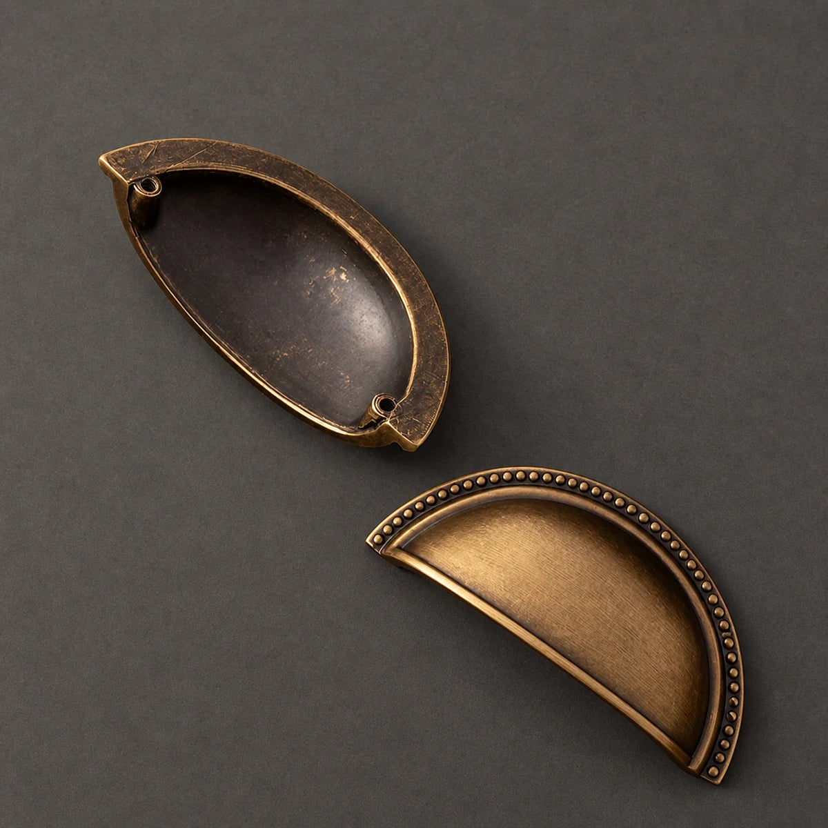 Front and rear of a deep beaded cup pull showing two mounting sockets