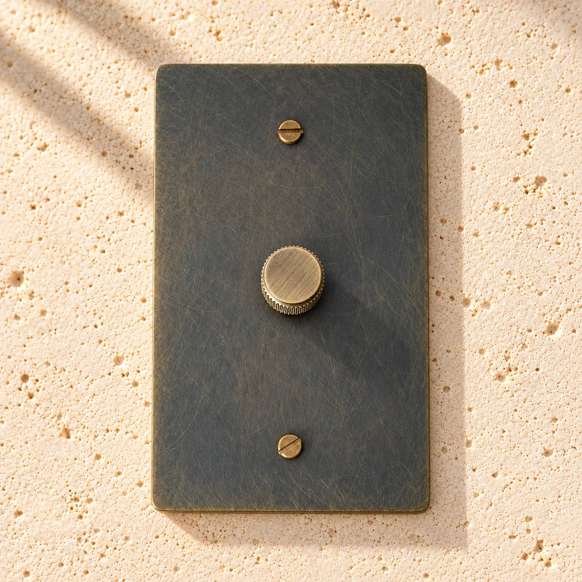 1-Gang Solid Brass Knurled Rotary Dimmer Light Switch on sunlit pale limestone
