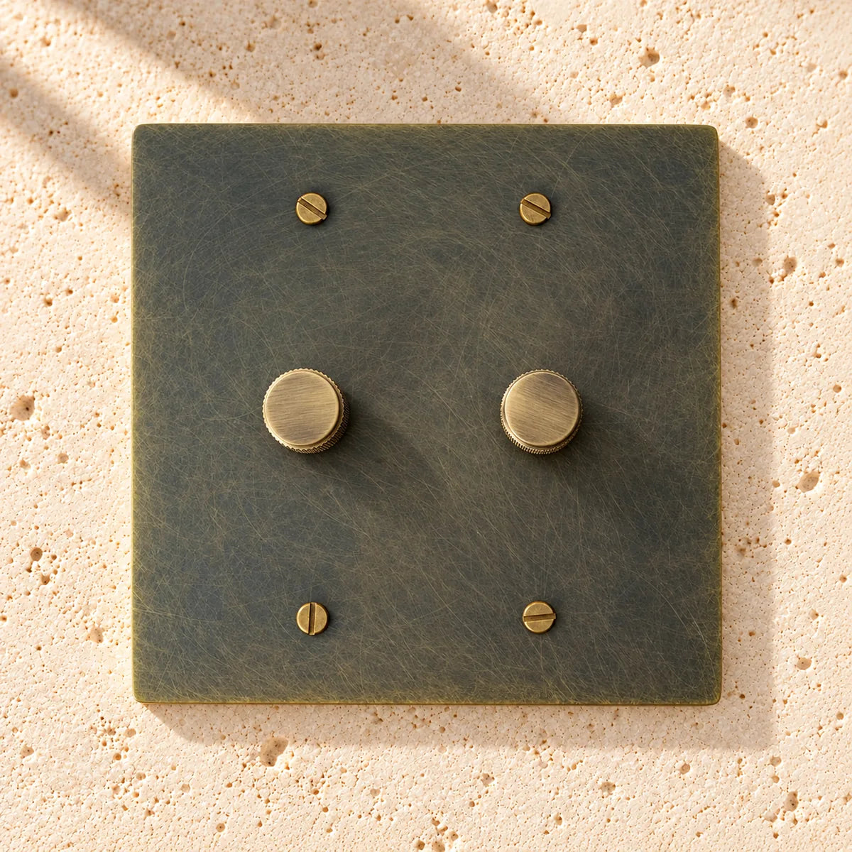 2-Gang Solid Brass Knurled Rotary Dimmer Light Switch on sunlit pale limestone