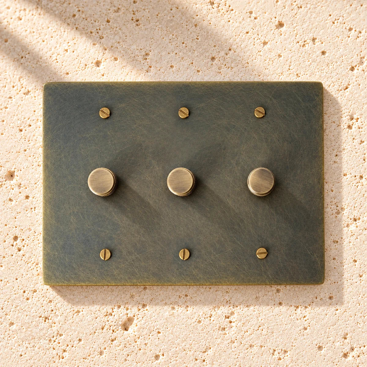 3 gang Bronze brass dimmer switch plate with antique knob on a white background